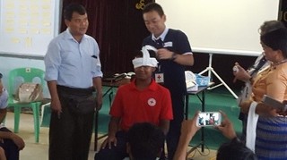 現地の救急法指導者へ三角巾の包帯を教える日赤指導員（ミャンマー）