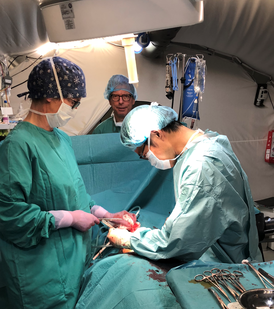 フィールドホスピタルで緊急開腹手術を行う米川医師（右）