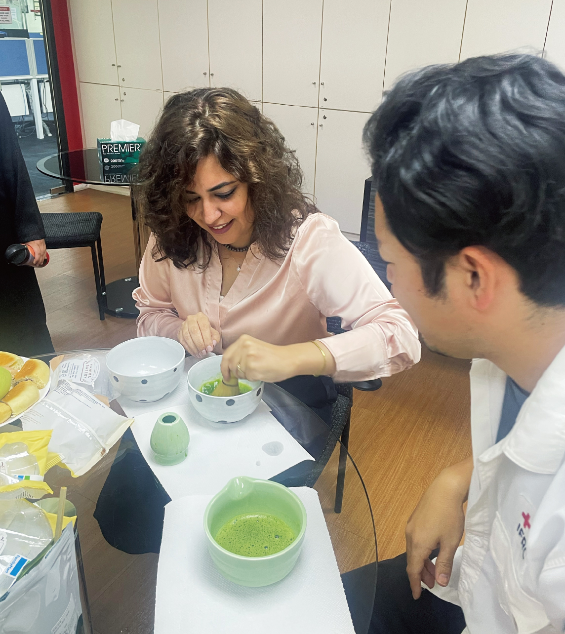 オフィスでも、ささやかな文化交流。IFRCのスタッフに茶道のお茶の点て方を伝える日赤職員（右）