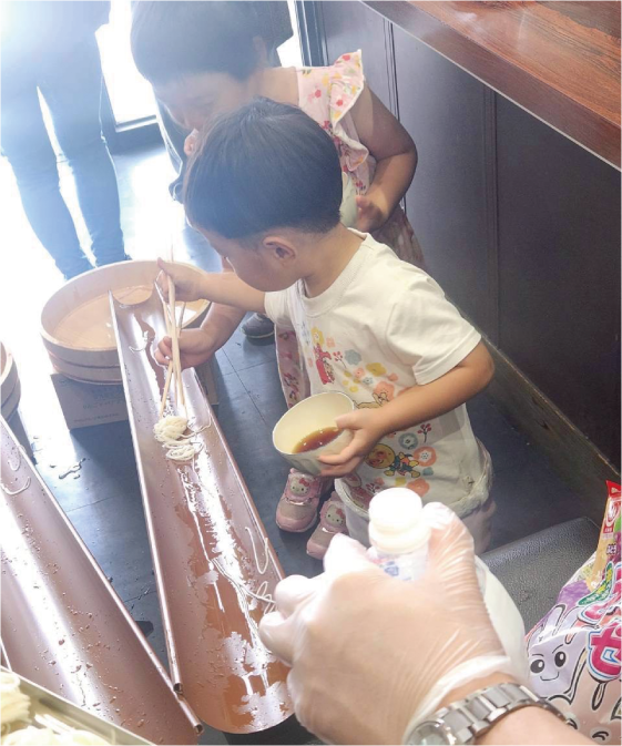 流しそうめんを楽しむ子どもたち
