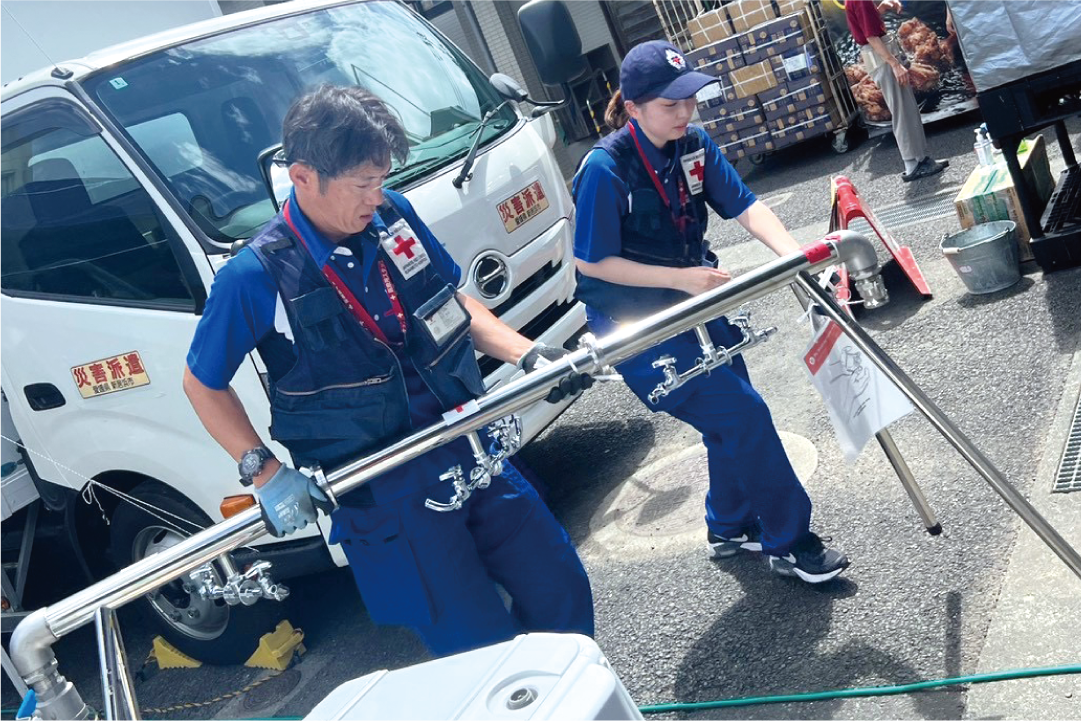 WASHチームで手洗い場の水道を設置する富田さん