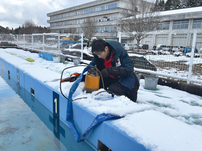 和倉小学校_雪の中のプールの水をくみ上げ.jpg