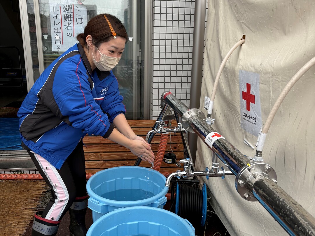 Woman impressed by the water coming out of the faucet and using it.jpg
