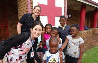 南アフリカ赤十字社のエイズ孤児も所属するキッズクラブ（学童保育）の子どもたちとふれあう鄭恵梨看護師（南アフリカ）