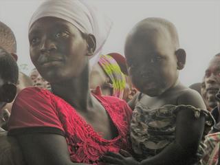 ブルンジ赤十字社が行った映画上映に見入る女性と子ども