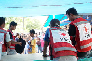子供たちに学校セットを配付するインドネシア赤十字社ボランティア