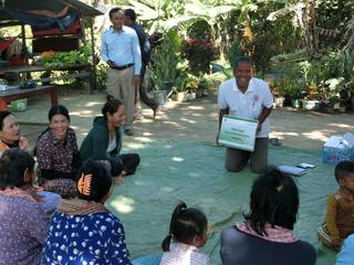 村民に紙芝居でメッセージを伝えるボランティア