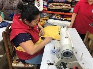 ベッドシーツを縫う赤十字ボランティア