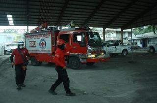 フィリピン赤十字社による住民支援。道路は灰でおおわれている。©IFRC