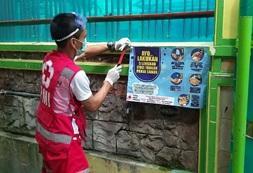 ロンボク島で手洗い啓発ポスターを掲示する赤十字ボランティア