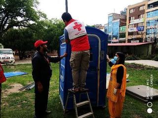 隔離施設で簡易トイレを設置するネパール赤十字社職員