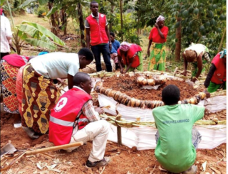 畑で使う堆肥の作り方を指導するルワンダ赤十字社のボランティア