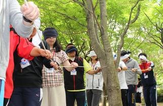 フィールドワークで目隠しをしながらロープをたどって歩く様子