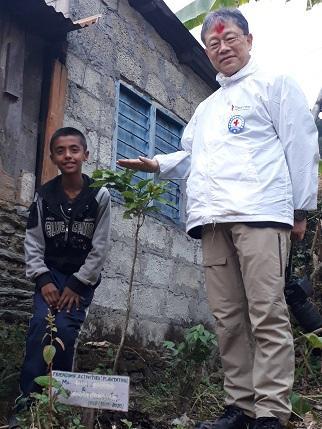 1年の月日をかけて成長した木を囲むKajarくんと先生