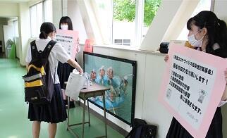 パネルを手に持ち募金活動を行うメンバー