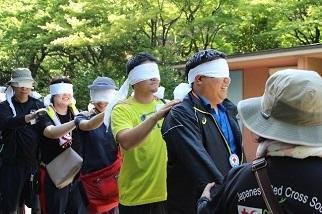 フィールドワークで目隠しをしながらロープをたどって歩く様子